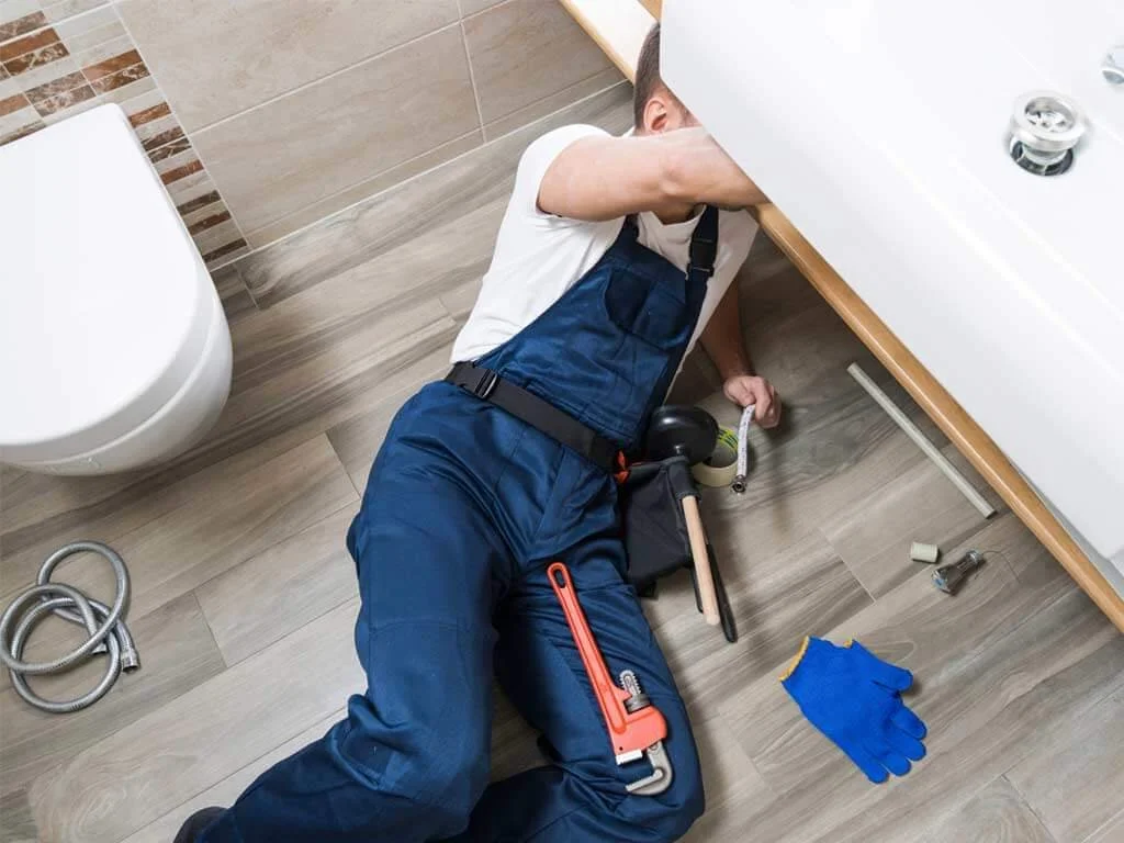 our plumber under sink to fix the plumbing problems