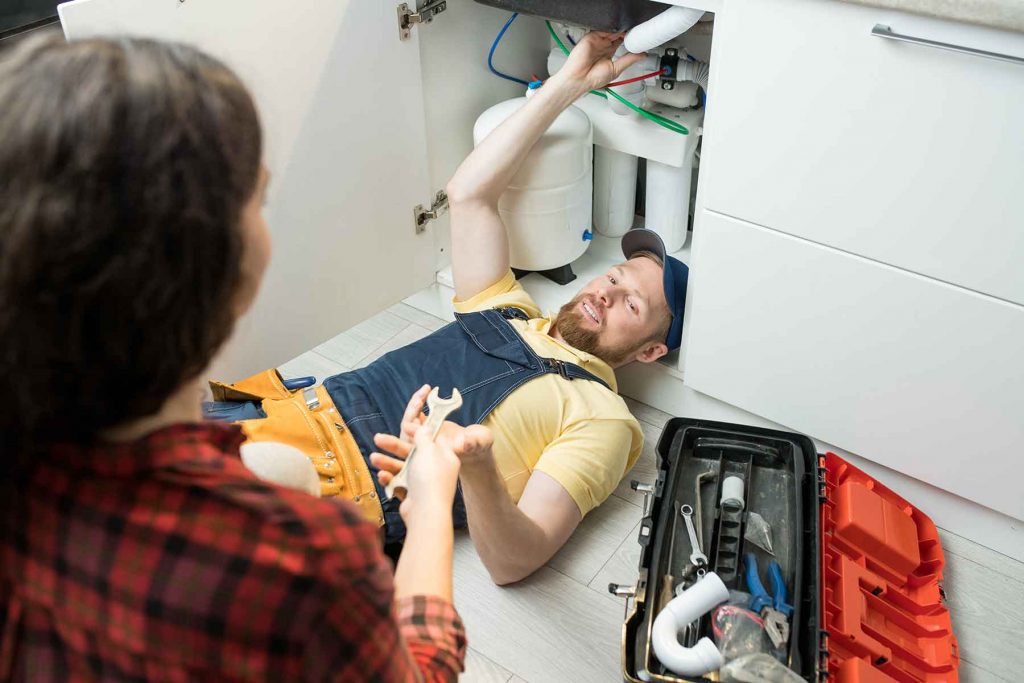 plumber fixing sink pipe